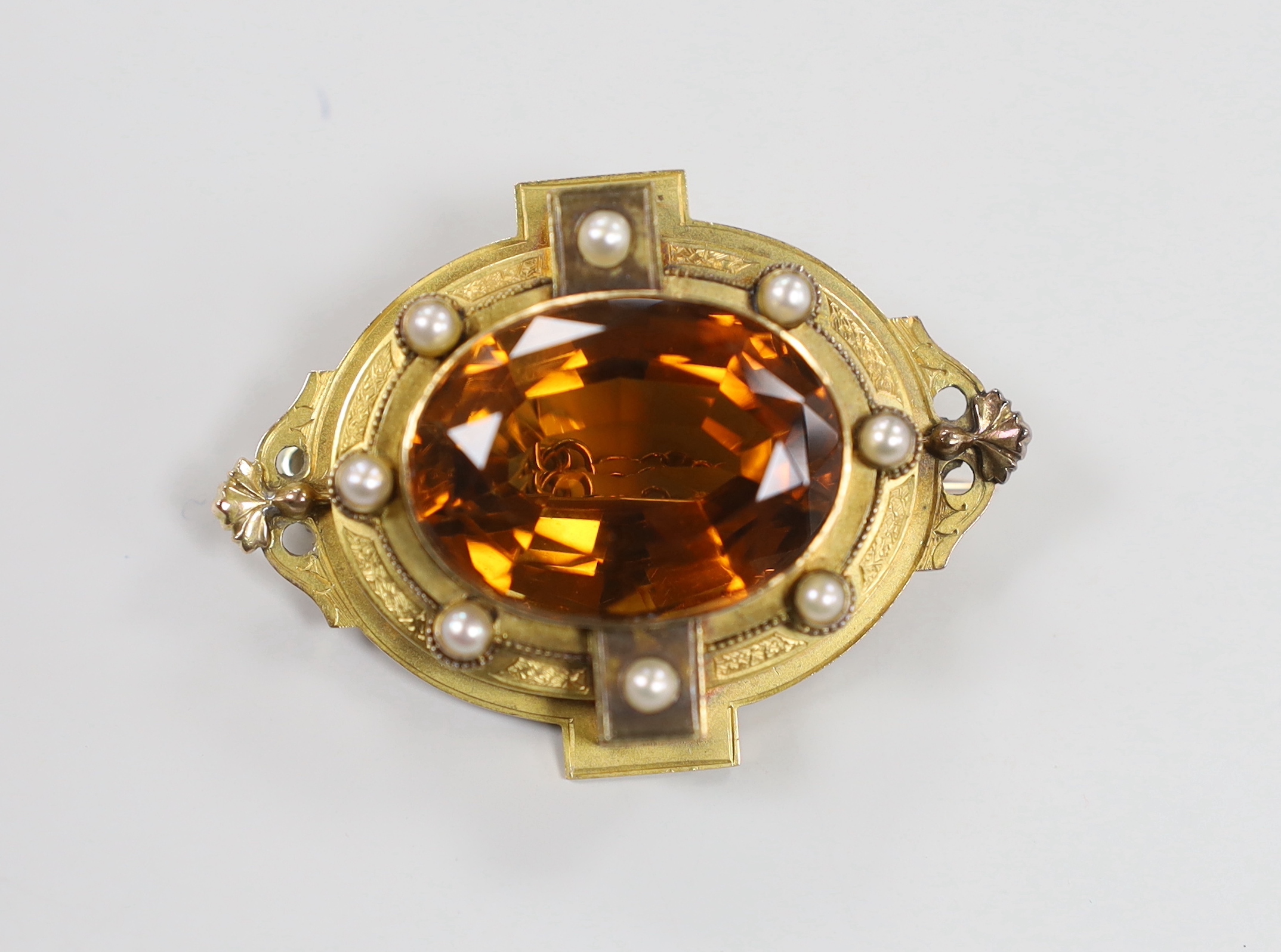 A Victorian yellow metal and large oval cut citrine set brooch, with split pearl set border, 51mm, gross weight 26.6 grams.